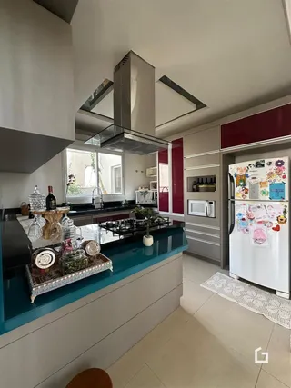 Vista da cozinha moderna com armários e bancadas escuras.