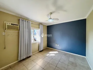 Ambiente interno de uma sala com piso de cerâmica e parede azul.