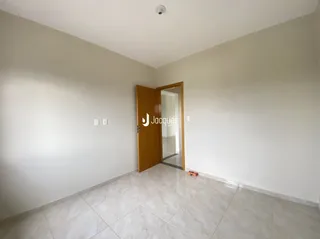 Vista interna de um ambiente com paredes brancas e piso de cerâmica.