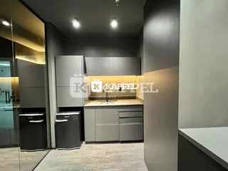 Foto de uma cozinha com armários escuros e bancada.