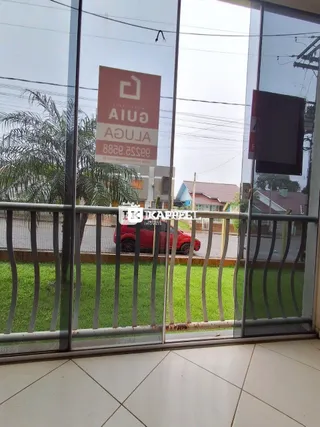 Vista externa de uma propriedade com grandes portas de vidro e um letreiro visível.