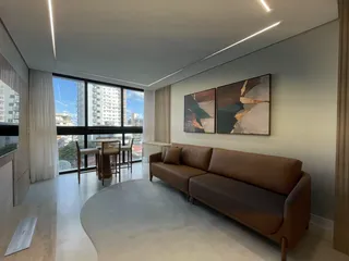 Sala de estar moderna com grandes janelas e vista para a cidade.