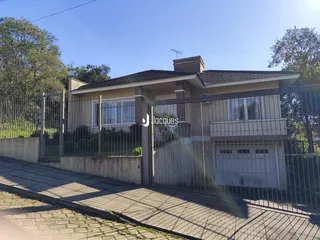 A fachada de uma casa em Lajeado, Brasil, com cerca e portão de ferro.