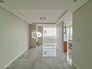 Hall de entrada amplo com piso de porcelanato claro e teto alto.