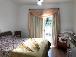 Foto de um quarto com cama e cortinas em uma residência.