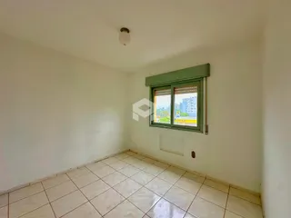 Vista interna de um cômodo com piso de cerâmica clara e paredes brancas.