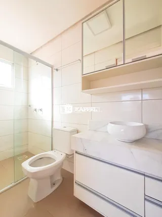 Banheiro moderno com revestimento branco e bancada de mármore.