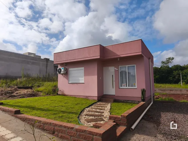 Fachada de uma casa em Lajeado, Brasil com jardim gramado e muro de tijolos.