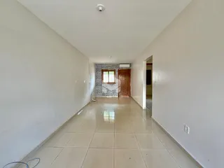 Corredor interno de uma residência com piso de cerâmica claro.