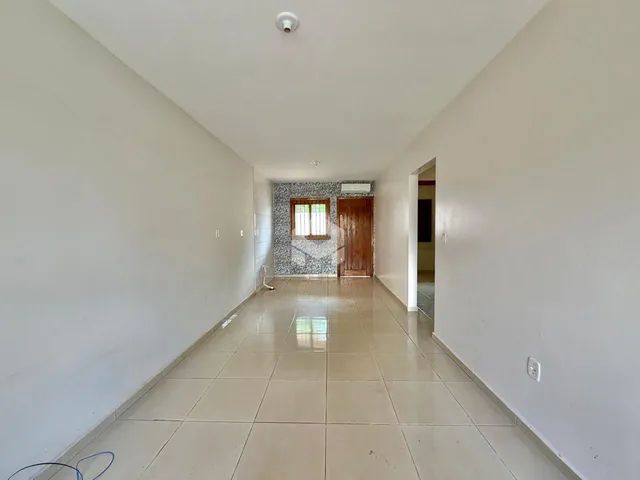 Corredor interno de uma residência com piso de cerâmica claro.