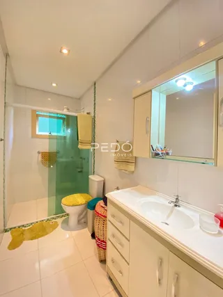 Foto de um banheiro com piso de cerâmica branca e azulejos.