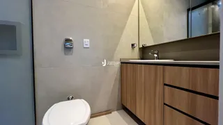 Banheiro com armários de madeira e vaso sanitário.