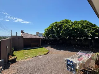 Vista externa da propriedade com gramado e vegetação exuberante.