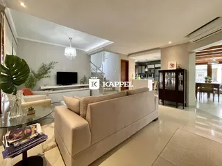 Sala de estar com sofá grande e televisão em um apartamento.