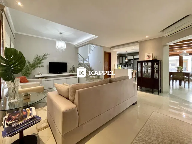 Sala de estar com sofá grande e televisão em um apartamento.