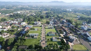 Vista aérea de uma propriedade residencial com áreas verdes e campos no entorno.