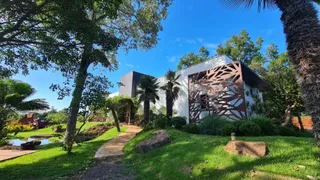 Fachada de uma casa em Lajeado, Brasil, com jardim gramado e árvores.