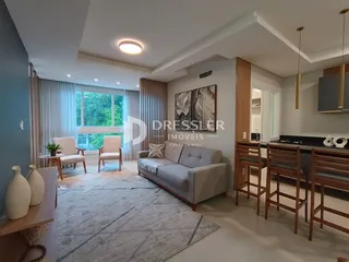 Sala de estar com grandes janelas e decoração moderna em um imóvel no Brasil.