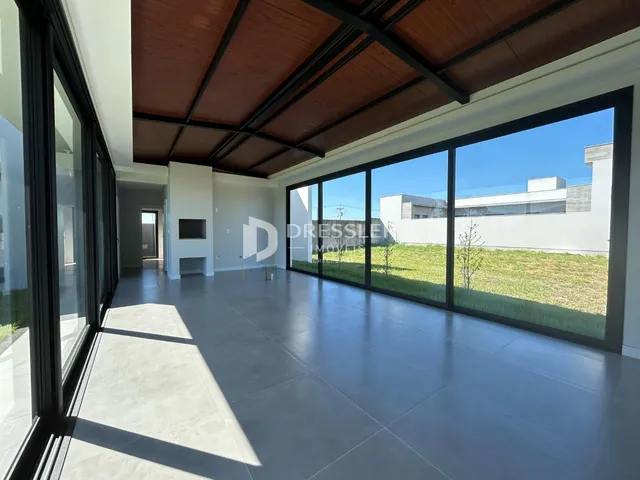 Uma sala de estar moderna com grandes janelas que oferecem vista para o exterior.