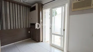A sala apresenta revestimento de madeira e piso cerâmico claro.