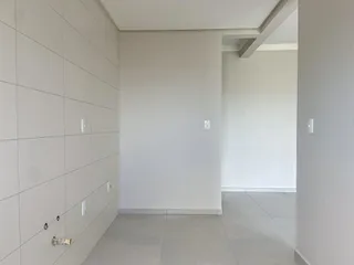 Hall de entrada com paredes brancas e piso de porcelanato claro.