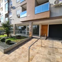 Vista externa com piso de cerâmica e grade de proteção em uma área de lazer.