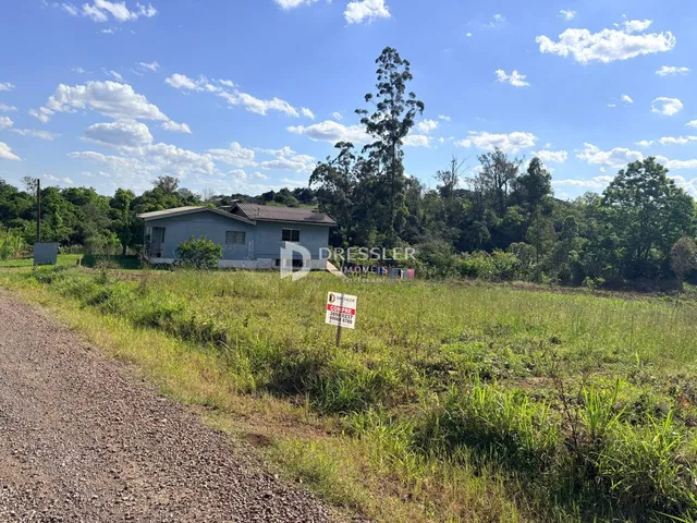 Casa em área rural com vegetação densa ao redor.
