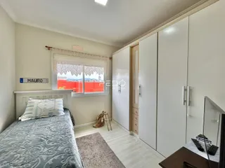 Quarto com cama e armários embutidos brancos.