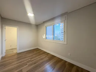 Ambiente interno com piso de madeira e janela.