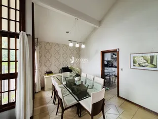 Sala de jantar com mesa de vidro e cadeiras em um imóvel no Brasil.