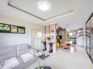 Sala de estar com sofá e área de jantar visível em um apartamento.