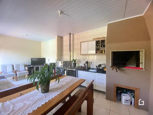 Ambiente interno de uma sala de estar com cozinha em uma residência no Brasil.