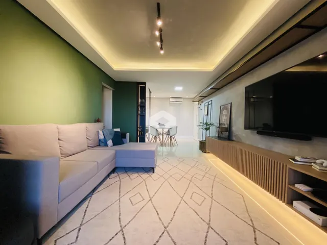 Sala de estar moderna com sofá e decoração clara.