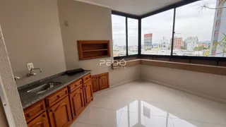 Vista interna de uma sala com grande janela de vista para a cidade.