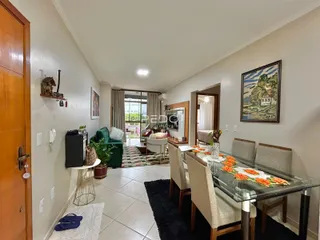 Ambiente interno de sala de jantar com mesa de vidro e cadeiras.
