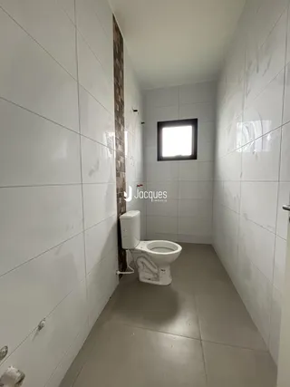 Foto de um corredor de banheiro com revestimento de cerâmica branca.