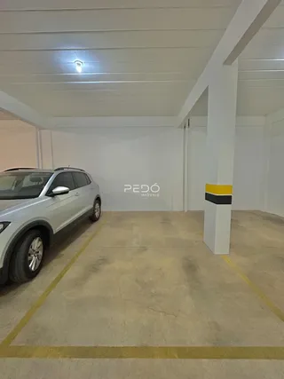 Interior de um espaço amplo com teto branco e coluna estrutural.