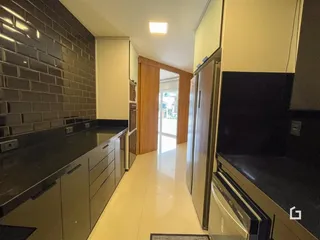 Cozinha moderna com armários e bancadas escuras.