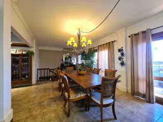 Sala de jantar com mesa de madeira e piso de madeira.