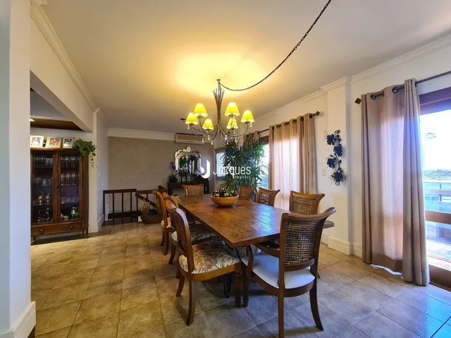 Sala de jantar com mesa de madeira e piso de madeira.