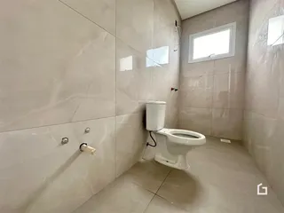 A foto mostra o interior de um banheiro com revestimento de cerâmica.