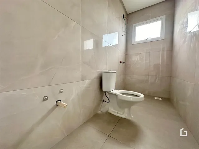 A foto mostra o interior de um banheiro com revestimento de cerâmica.