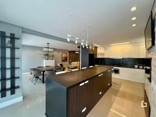 Vista ampla de uma cozinha e sala de jantar moderna em um imóvel.