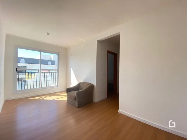 Sala de estar com piso de madeira e janela iluminada