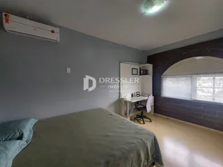 Quarto com cama e janela em ambiente com parede de destaque.