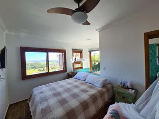 Quarto com cama e janela de madeira em uma residência no Brasil.
