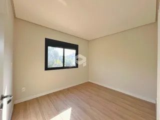 Sala de estar com piso de madeira clara e janela.