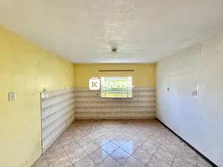 Foto interna de um cômodo com piso de cerâmica e paredes amarelas.