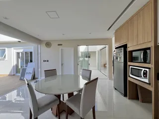 Sala de jantar com mesa redonda e cadeiras em um apartamento em Lajeado.