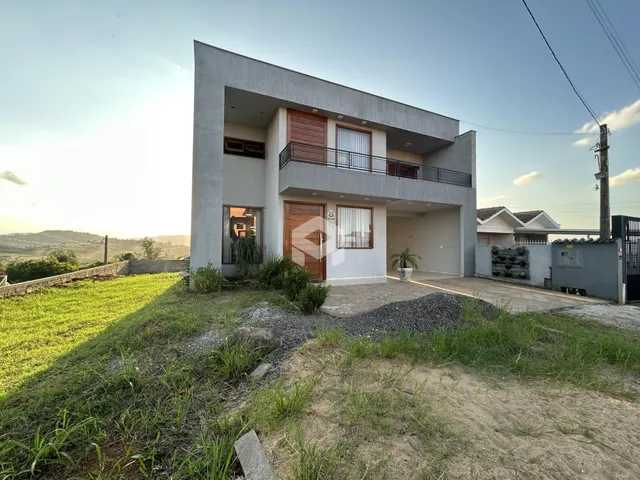 Fachada de uma casa moderna em Lajeado, Brasil, com jardim em primeiro plano.